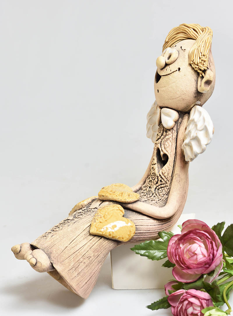 Keramický anděl sedící se srdíčkem kluk