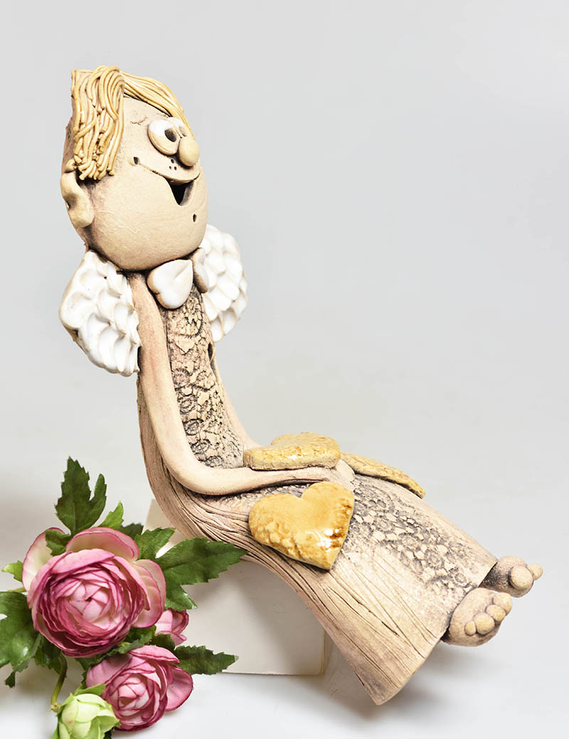 Keramický anděl sedící se srdíčkem kluk